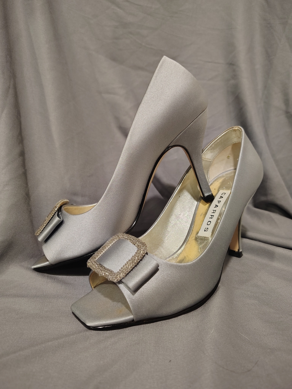 CAPARROS Silver Satin Peep-Toe Heels with Rhinestone Buckle